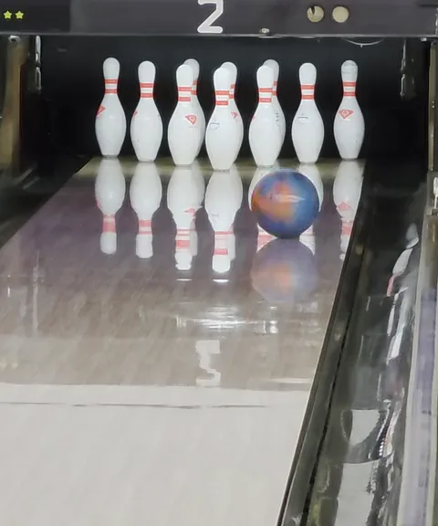 Her lane, filmed: the ball rolling into a full rack of ten pins.
