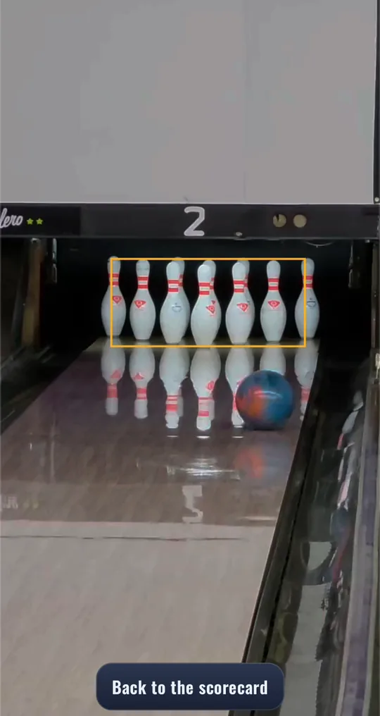 The camera's whole-screen view of the lane: a ball rolling into the full rack, the deck boxed in amber.